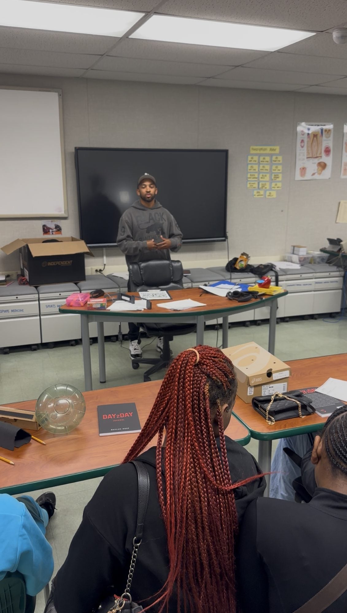 Daylan West speaking at the front of a classroom while students listen